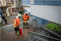 Einer von 275 Einsätzen der Backnanger Feuerwehr im Jahr 2024: In der Spaltgasse löschen zwei Wehrleute einen brennenden Mülleimer. Foto: Alexander Becher