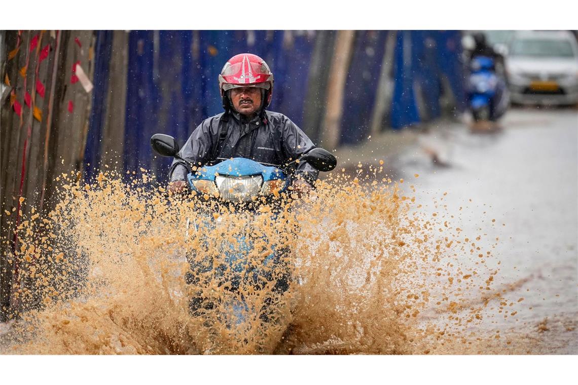 Ein Mann bahnt sich in Guwahati, Indien, den Weg durch die Überflutungen nach schweren Monsunregenfällen.