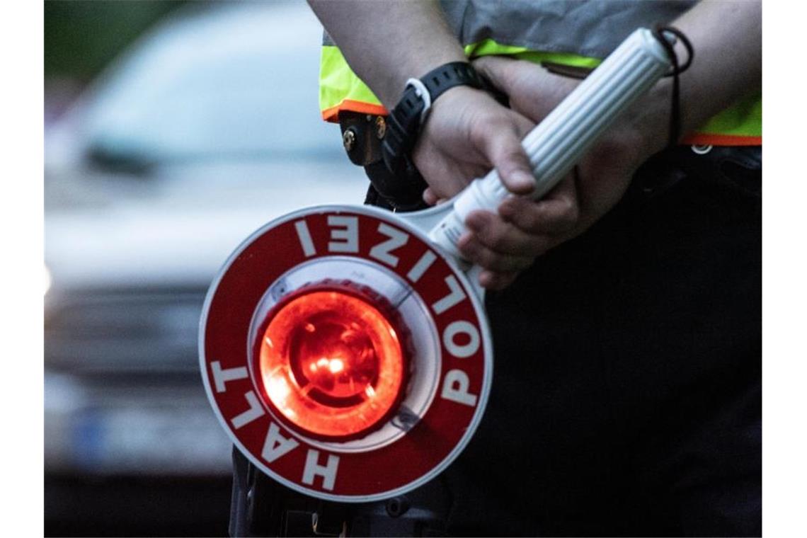 Ein Polizist hält bei einer Verkehrskontrolle eine Winkerkelle in der Hand. Foto: Paul Zinken/dpa/ZB/Symbolbild