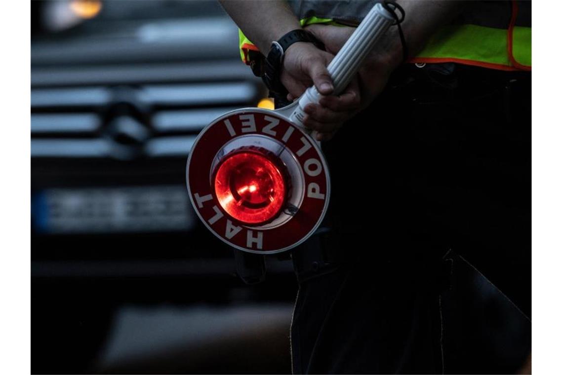 Ein Polizist hält bei einer Verkehrskontrolle eine Winkerkelle in der Hand. Foto: Paul Zinken/dpa/Symbolbild