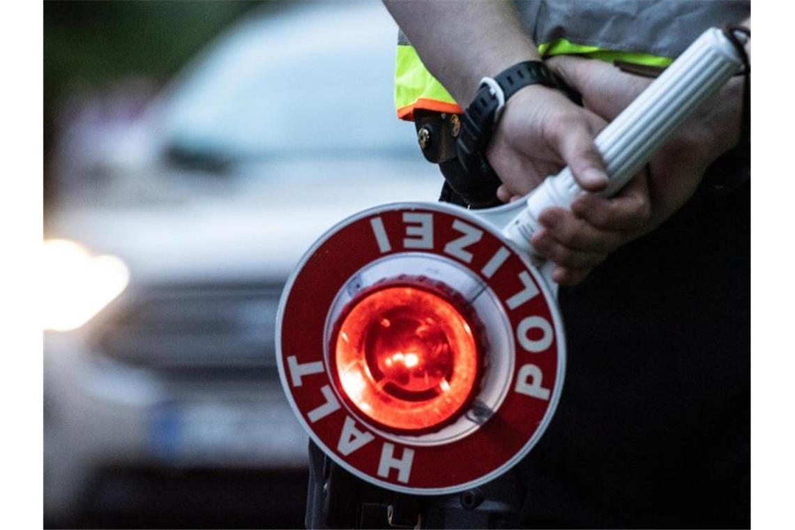 Ein Polizist hält bei einer Verkehrskontrolle eine Winkerkelle in der Hand. Foto: Paul Zinken/dpa/ZB/Symbolbild