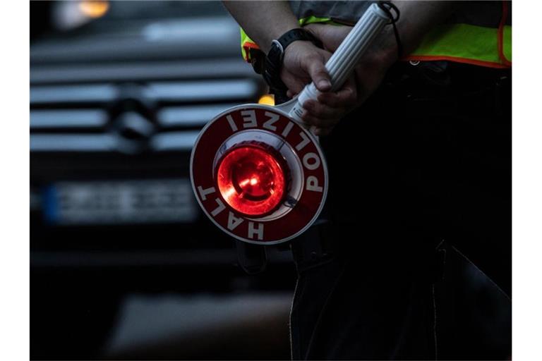 Ein Polizist hält bei einer Verkehrskontrolle eine Winkerkelle in der Hand. Foto: Paul Zinken/dpa/Symbolbild