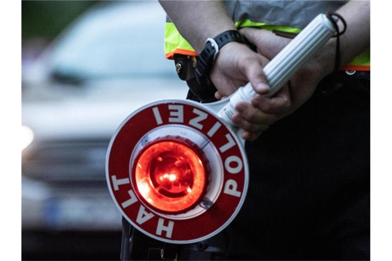 Ein Polizist hält bei einer Verkehrskontrolle eine Winkerkelle in der Hand. Foto: Paul Zinken/dpa/ZB/Symbolbild