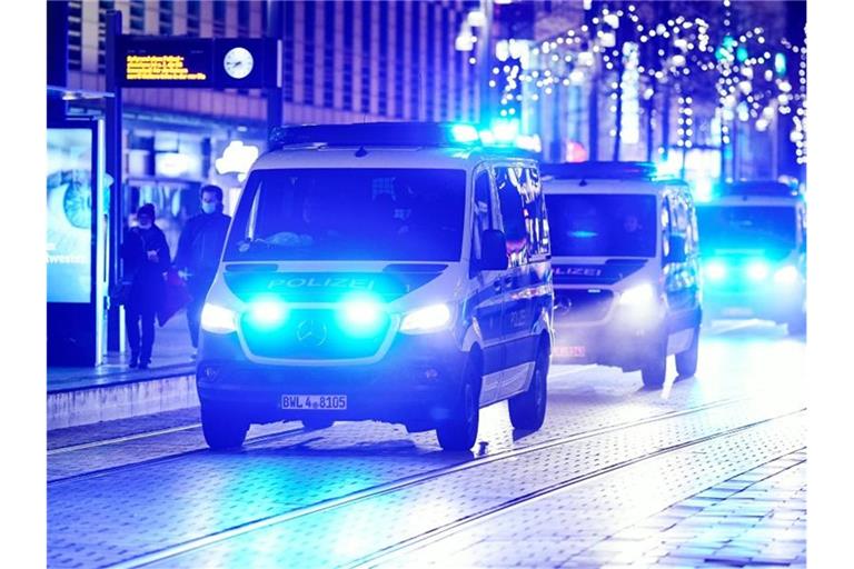 Einsatzfahrzeuge der Polizei fahren während eines Protests gegen die staatlichen Corona-Maßnahmen durch Mannheim. Foto: Uwe Anspach/dpa