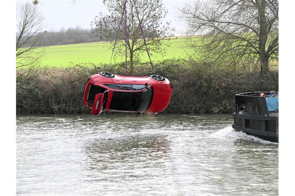 Einsatzkräfte bergen das Auto aus dem Fluss. Foto: Bernd Weißbrod/dpa