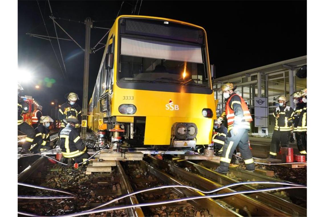 Einsatzkräfte der Feuerwehr heben die Stadtbahn U13 zurück auf die Schienen. Foto: Andreas Rosar/Fotoagentur-Stuttgart/dpa