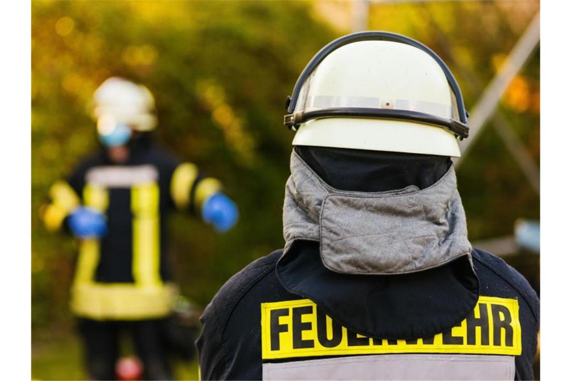 Einsatzkräfte der Feuerwehr in Schutzkleidung. Foto: Philipp von Ditfurth/dpa/Symbolbild