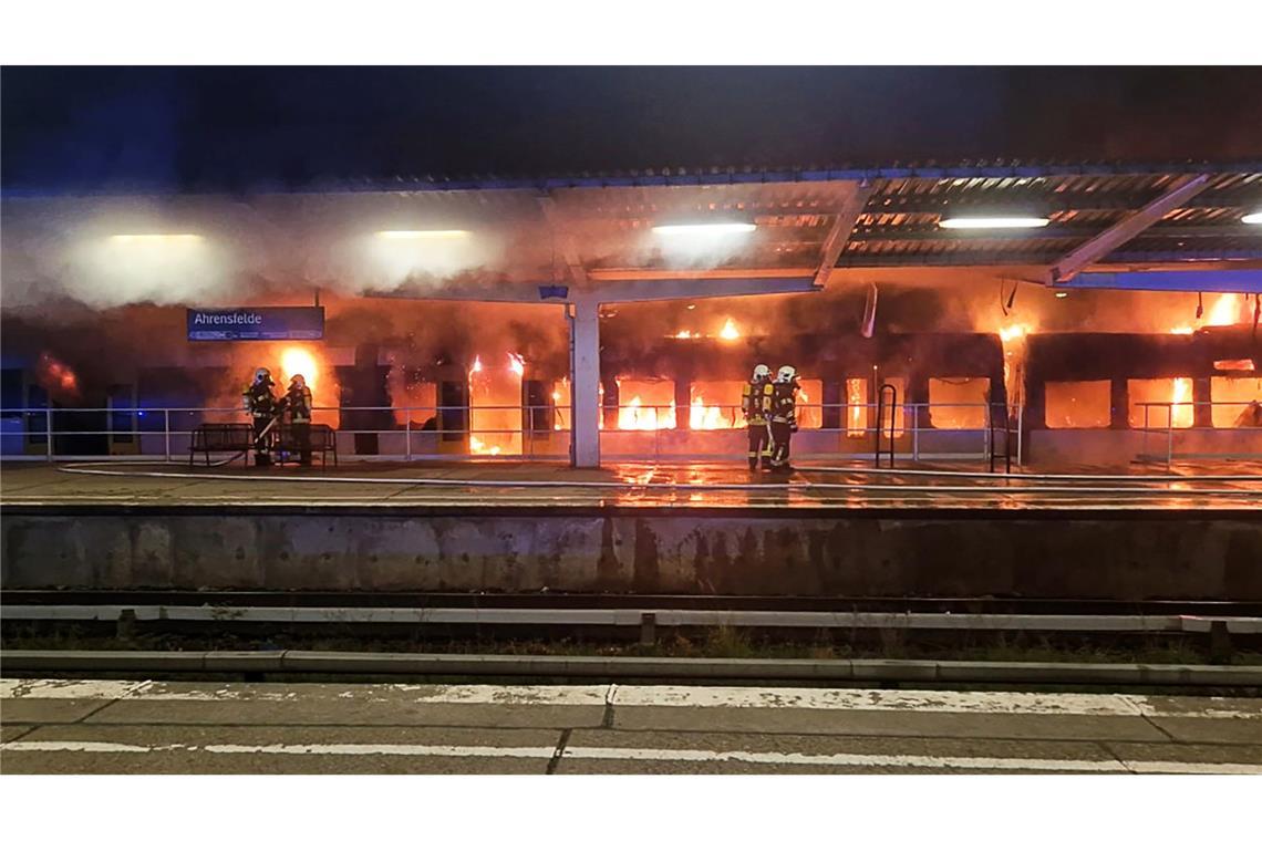 Einsatzkräfte der Feuerwehr löschen den Brand eines Zuges im S-Bahnhof Ahrensfelde.