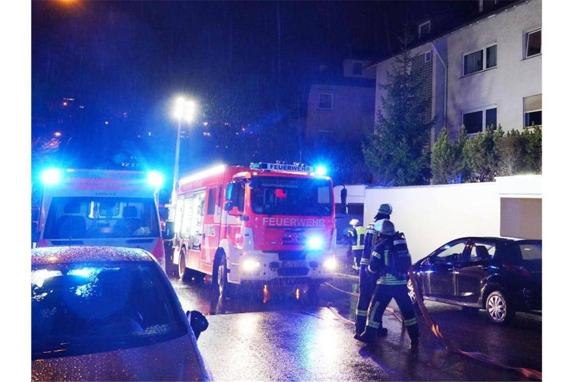 Einsatzkräfte der Feuerwehr, Rettungskräfte und Polizei stehen vor dem Mehrfamilienhaus. Foto: Andreas Rosar/dpa