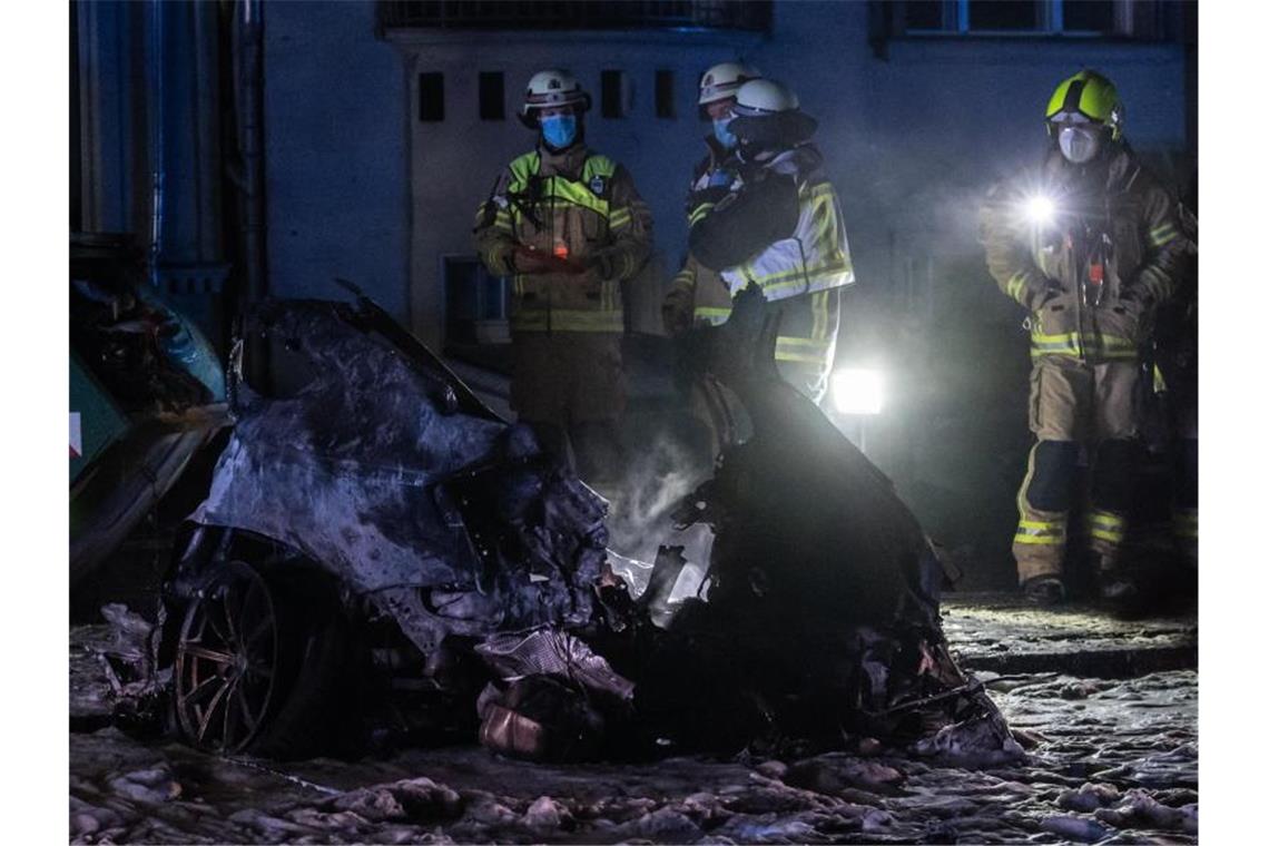 Horror-Crash in Berlin: Tote, ein Verdächtiger Einsatzkräfte der Feuerwehr stehen am Treptower Park neben dem Autowrack. Foto: Paul Zinken/dpa