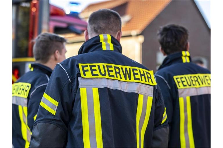 Einsatzkräfte der Feuerwehr stehen nebeneinander. Foto: David Inderlied/dpa/Symbolbild