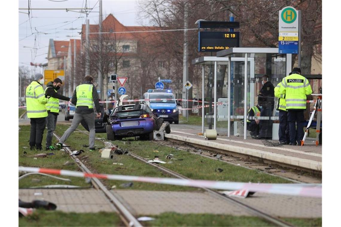 Auto fährt in Leipzig in Menschengruppe - drei Tote Einsatzkräfte der Polizei und Sachverständige sind an der Unfallstelle neben dem Unfallwagen im Gleisbett der Straßenbahn im Einsatz. Foto: Jan Woitas/dpa