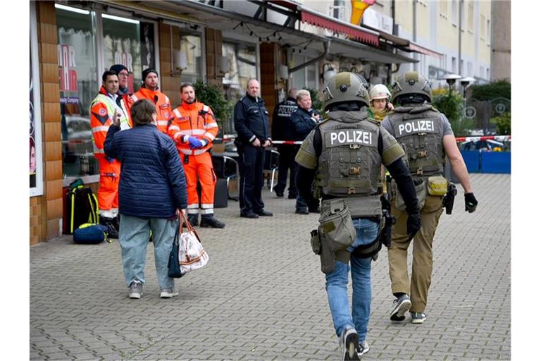 Einsatzkräfte der Rettungsdienste und der Polizei sind vor einem Mehrfamilienhaus im Einsatz. Foto: Rene Priebe/dpa