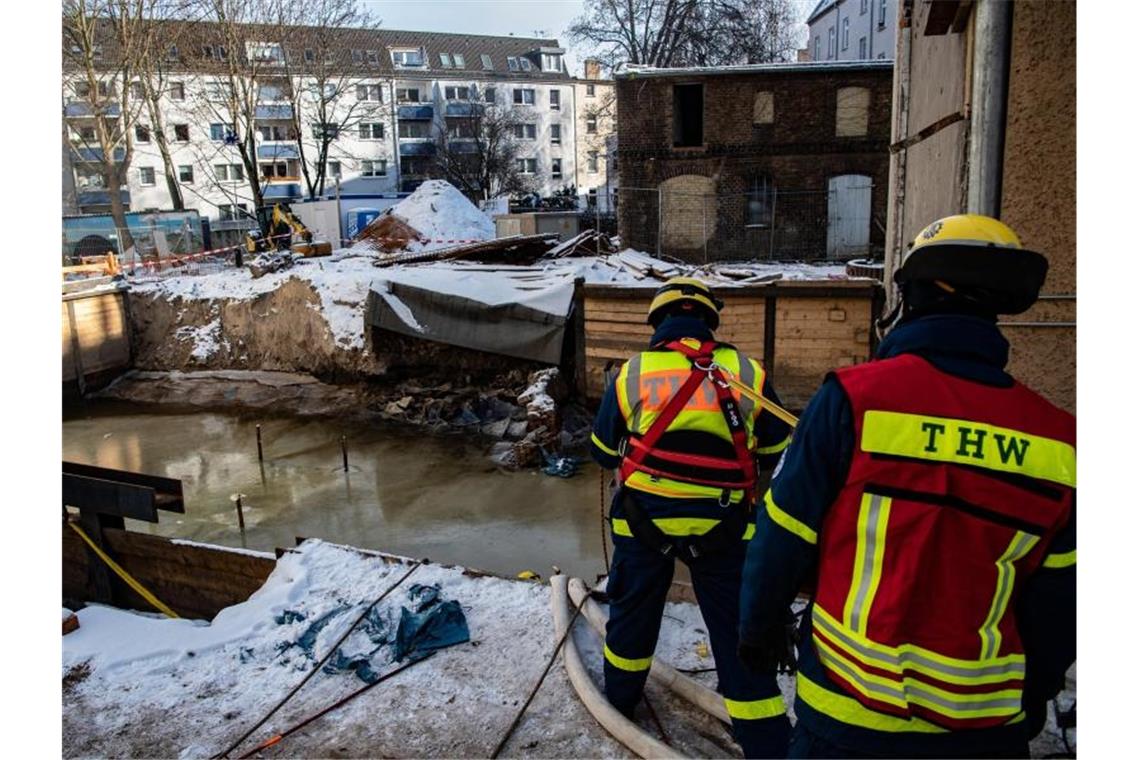 Nach Wassereinbruch: Bewohner dürfen wohl bald nach Hause Einsatzkräfte des Technischen Hilfswerks (THW) stehen an der mit Wasser gefüllten Baugrube in Berlin-Köpenick. Foto: Paul Zinken/dpa
