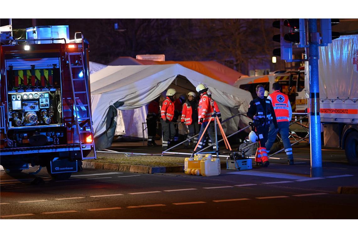 Einsatzkräfte von Rettungsdiensten sind im Einsatz bei einem Zelt für Verletze beim Weihnachtsmarkt in Magdeburg.