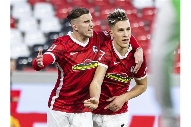 Ermedin Demirovic (l) jubelt mit seinem Teamkollegen Nico Schlotterbeck auf dem Spielfeld. Foto: Tom Weller/dpa/Archivbild