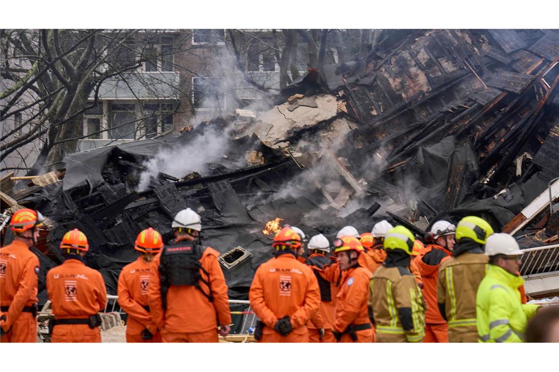 Explosion von Wohngebäude in Den Haag in den Niederlanden. Feuerwehrleute stehen vor einem zerstörten Gebäude am Ort einer Explosion, bei der mehrere Wohnungen zerstört und mehrere Personen verletzt wurden. Einige Menschen werden noch vermisst.