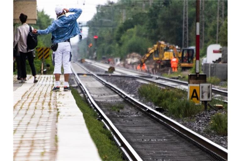 Fahrgäste warten auf einen Zug. Foto: Julian Stratenschulte/dpa