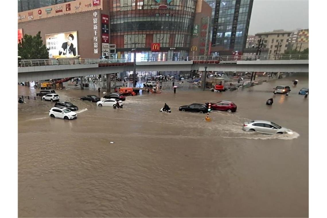 Überschwemmungen stürzen chinesische Metropole ins Chaos Fahrzeuge stehen in der zentralchinesischen Provinz Henan auf einer überfluteten Straße. Foto: Uncredited/CHINATOPIX/AP/dpa