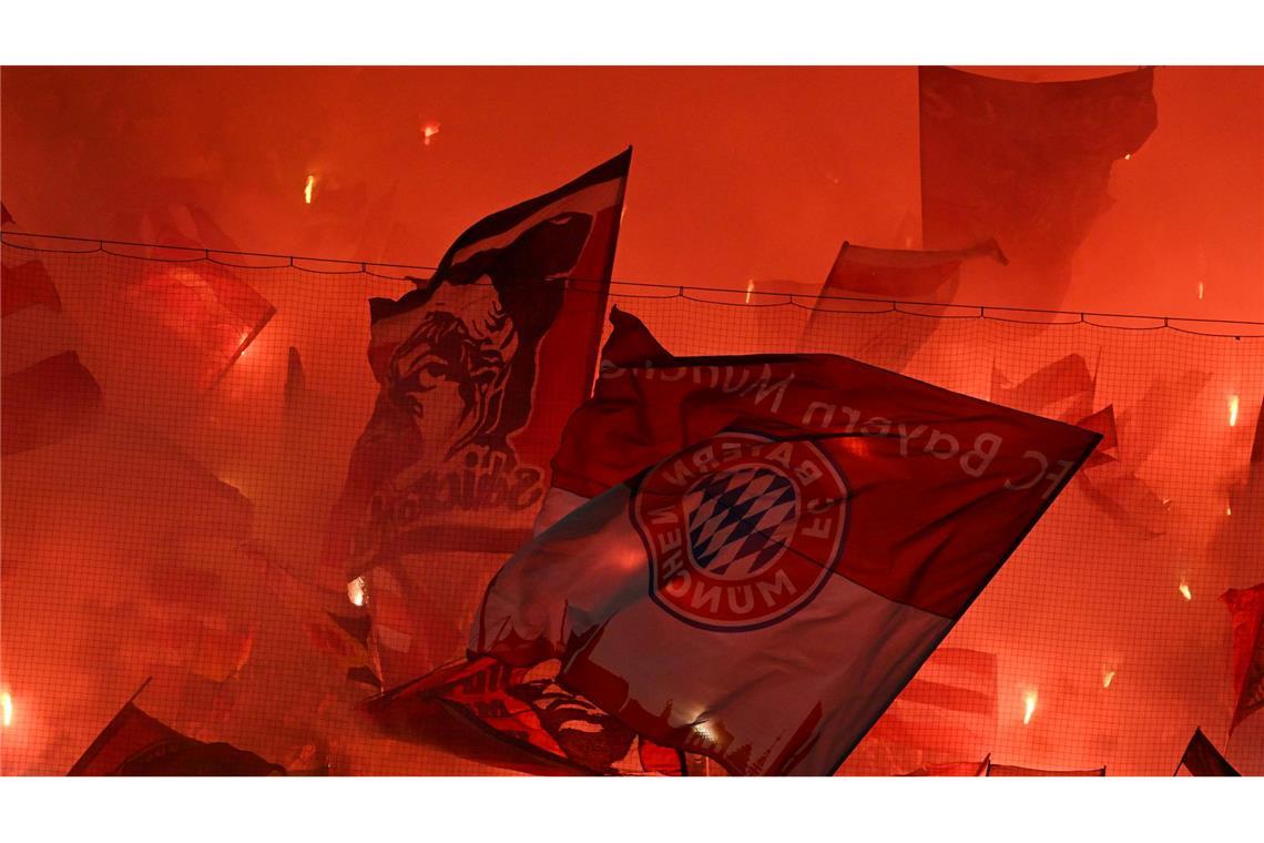 Fans schwenken Fahnen auf der Tribüne beim Spiel Bayern München gegen Bayer Leverkusen in der Champions League,