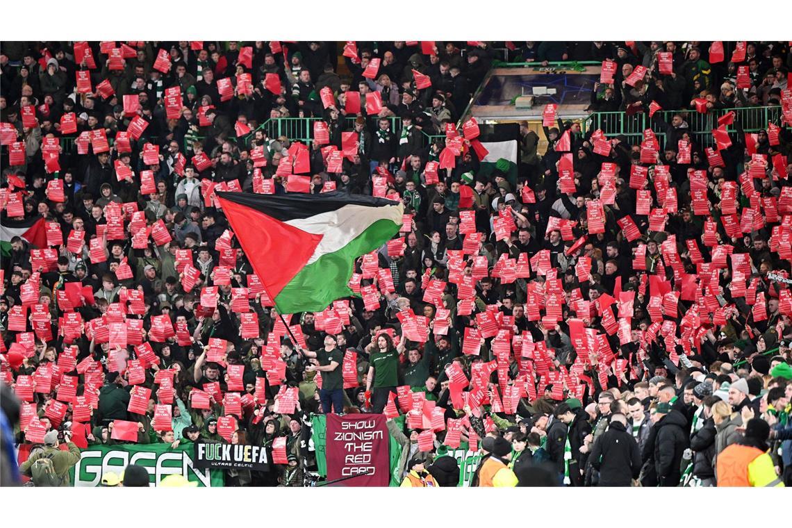 Fans von Celtic zeigen beim Spiel gegen Bayern München rote Karten und eine Flagge von Palästina.