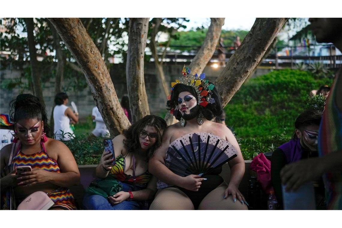 Feiernde sitzen auf einer Bank während der Gay Pride Parade in Panama-Stadt, die den Höhepunkt des Pride Month markiert.