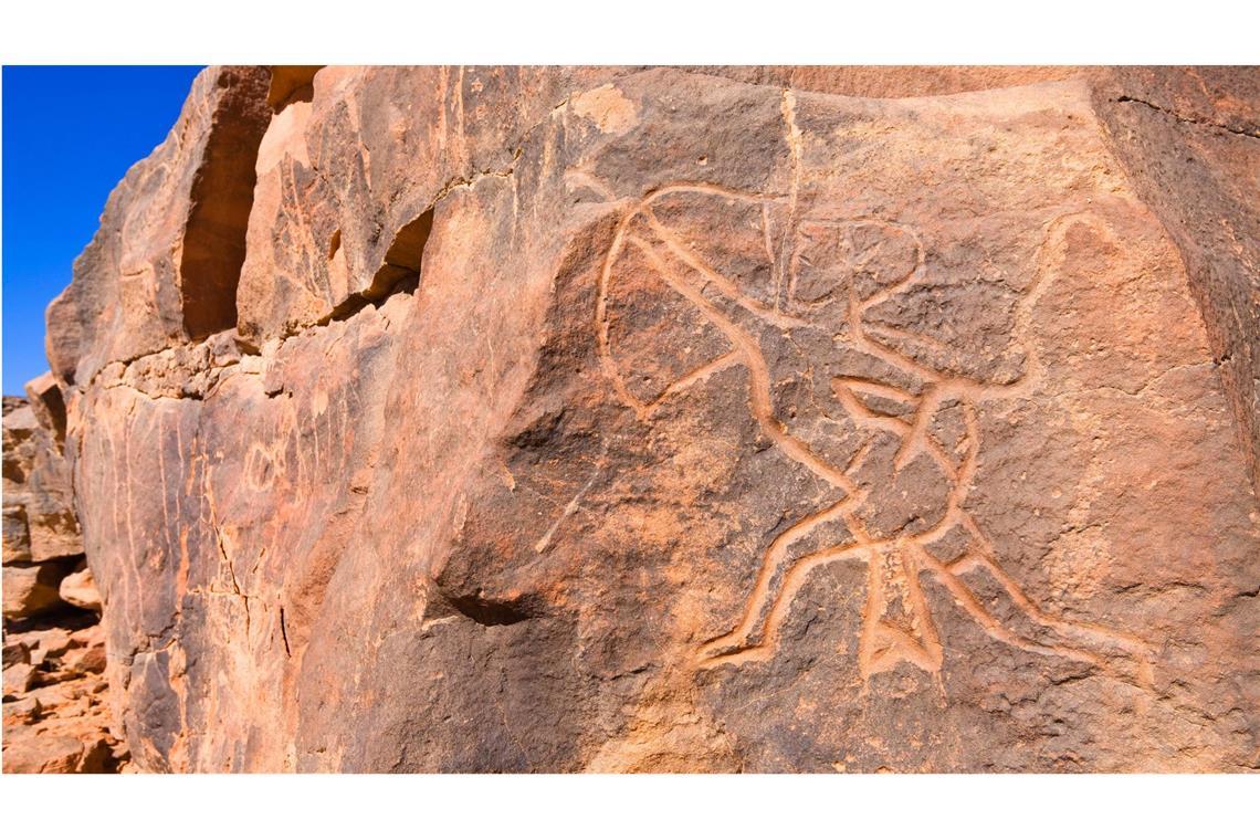 Felsgravur eines steinzeitlichen Jägers mit Pfeil und Bogen in der Steinwüste des Wadi Mathendous in  Libyen