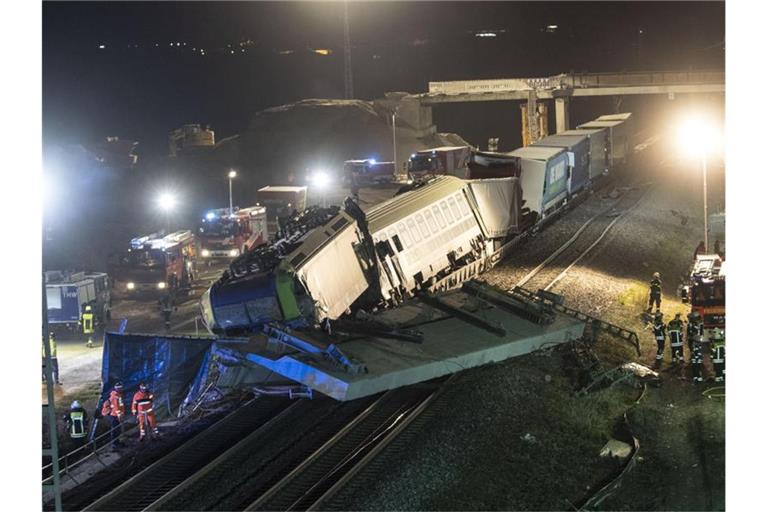 Feuerwehrfahrzeuge stehen um einen verunglückten Zug. Foto: Patrick Seeger/dpa