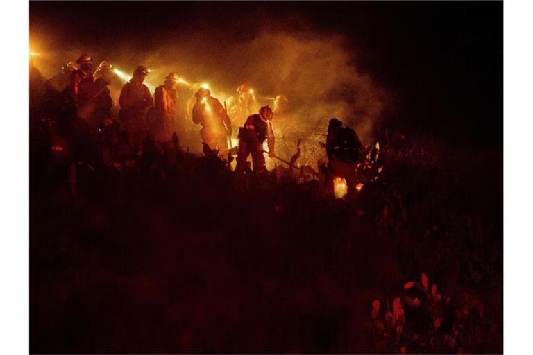 Feuerwehrleute bekämpfen Glutherde eines Buschfeuers, des sogenannten Castlewood Fire. Foto: Noah Berger/AP/dpa