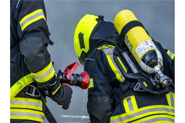 Feuerwehrleute bereiten einen Löschangriff vor. Foto: David Inderlied/dpa/Symbolbild