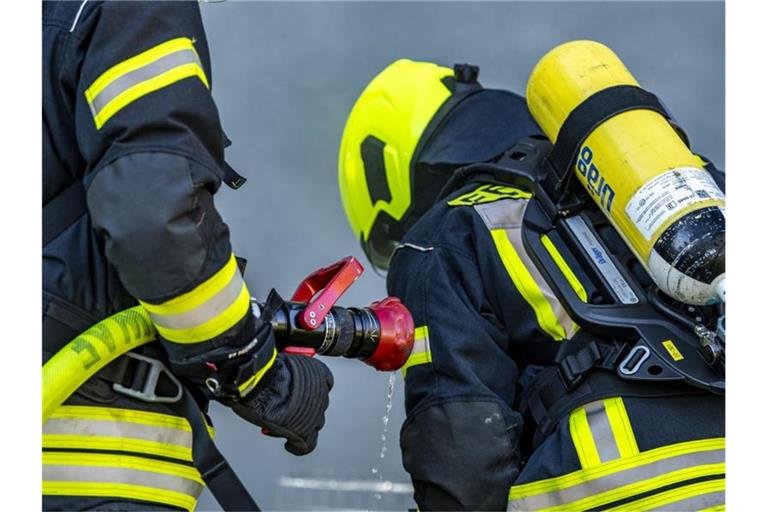 Feuerwehrleute bereiten einen Löschangriff vor. Foto: David Inderlied/dpa/Symbolbild