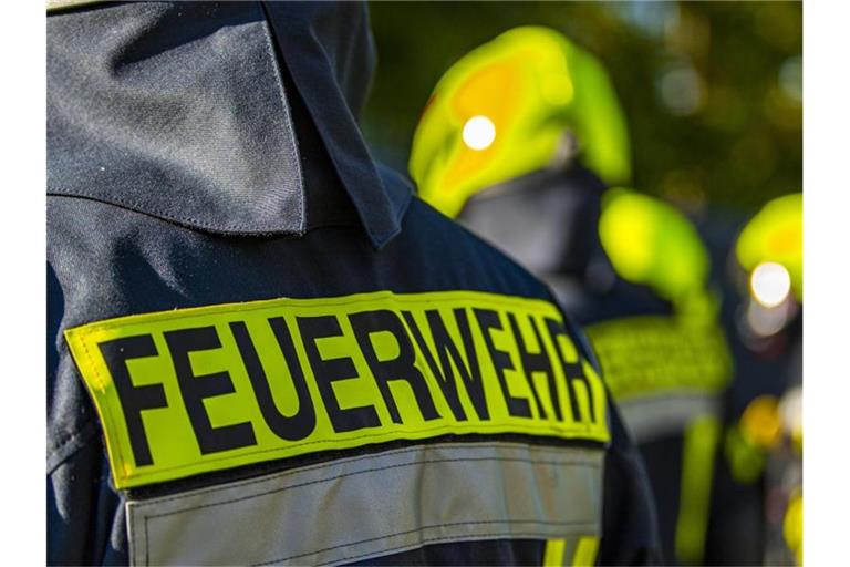 Feuerwehrleute stehen am Einsatzort zusammen. Foto: David Inderlied/dpa/Symbolbild