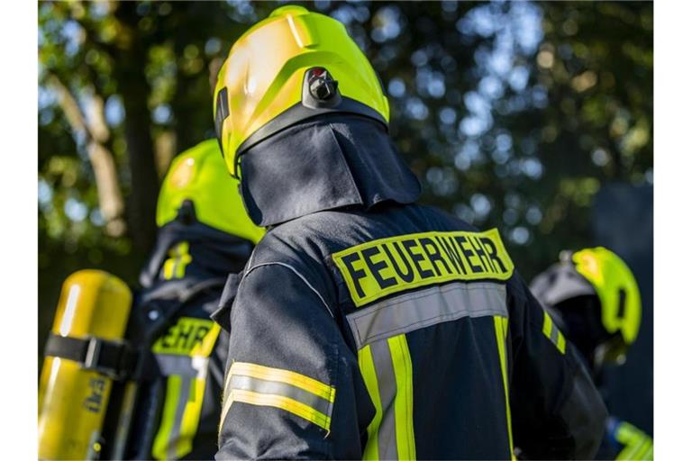 Feuerwehrleute stehen zusammen, um einen Einsatz zu besprechen. Foto: David Inderlied/dpa/Symbolbild