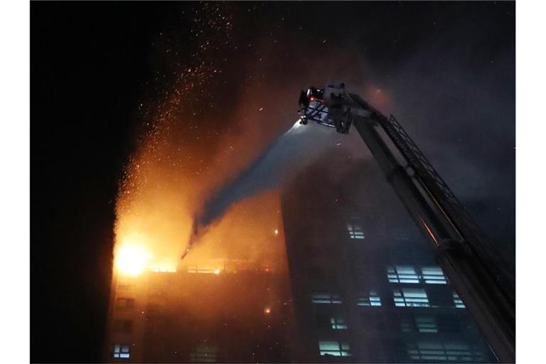 Feuerwehrleute versuchen, den Brand in einem Hochhaus zu löschen. Foto: -/YNA/dpa