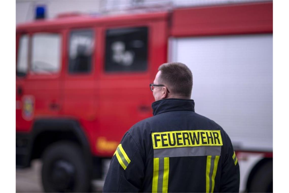 Brand in Mehrfamilienhaus in Wangen: vier Leichtverletzte Feuerwehrmänner stehen vor einem Feuerwehrauto. Foto: Jens Büttner/zb/dpa