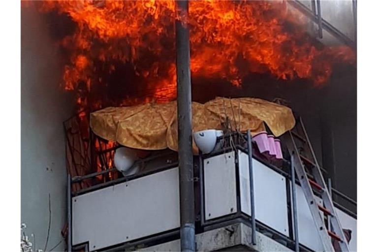 Flammen schlagen aus einer Wohung in einem Hochhaus. Foto: Karsten Schmalz/dpa