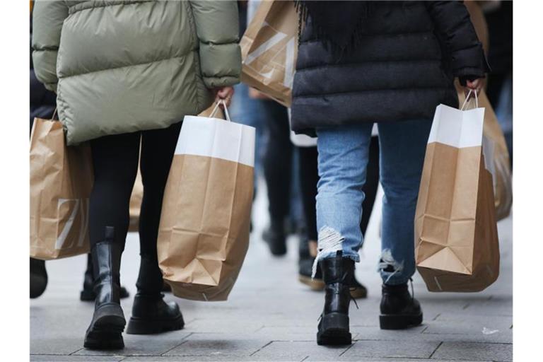 Frauen tragen Einkaufstüten in der Innenstadt. Foto: Martin Gerten/dpa/Archivbild