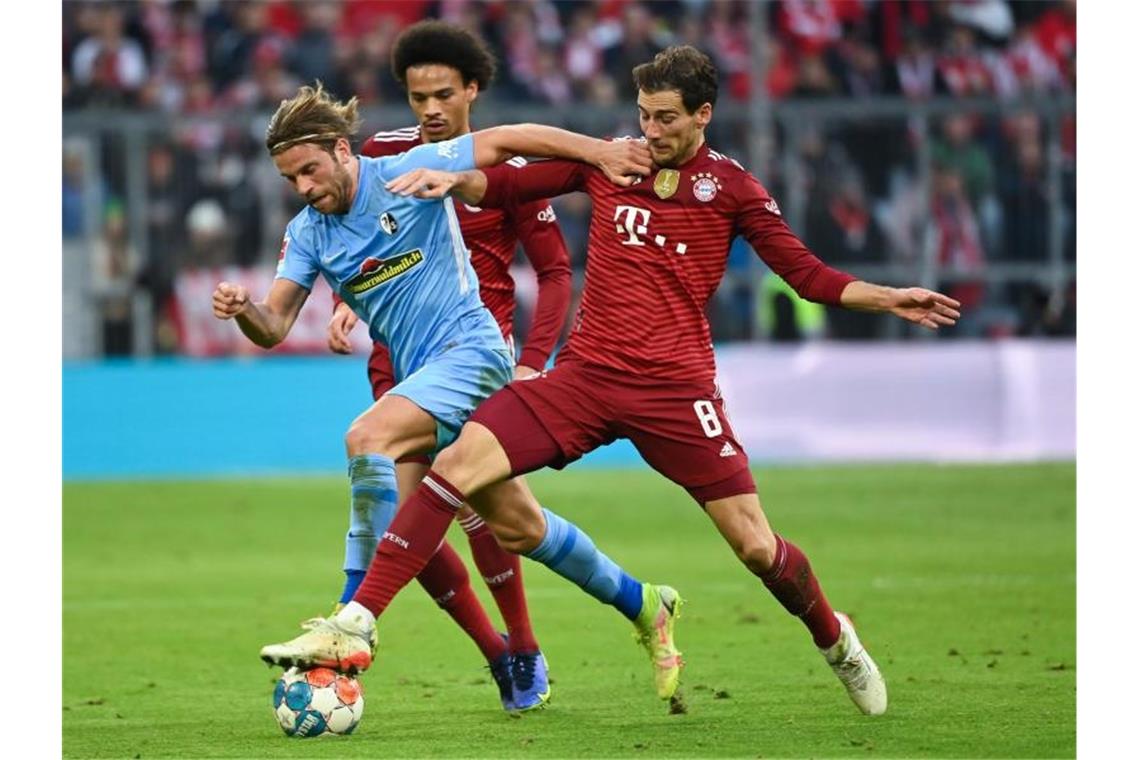 Freiburgs Lucas Höler (l) kämpft um den Ball mit Münchens Leroy Sane (hinten) und Münchens Leon Goretzka (r). Foto: Sven Hoppe/dpa