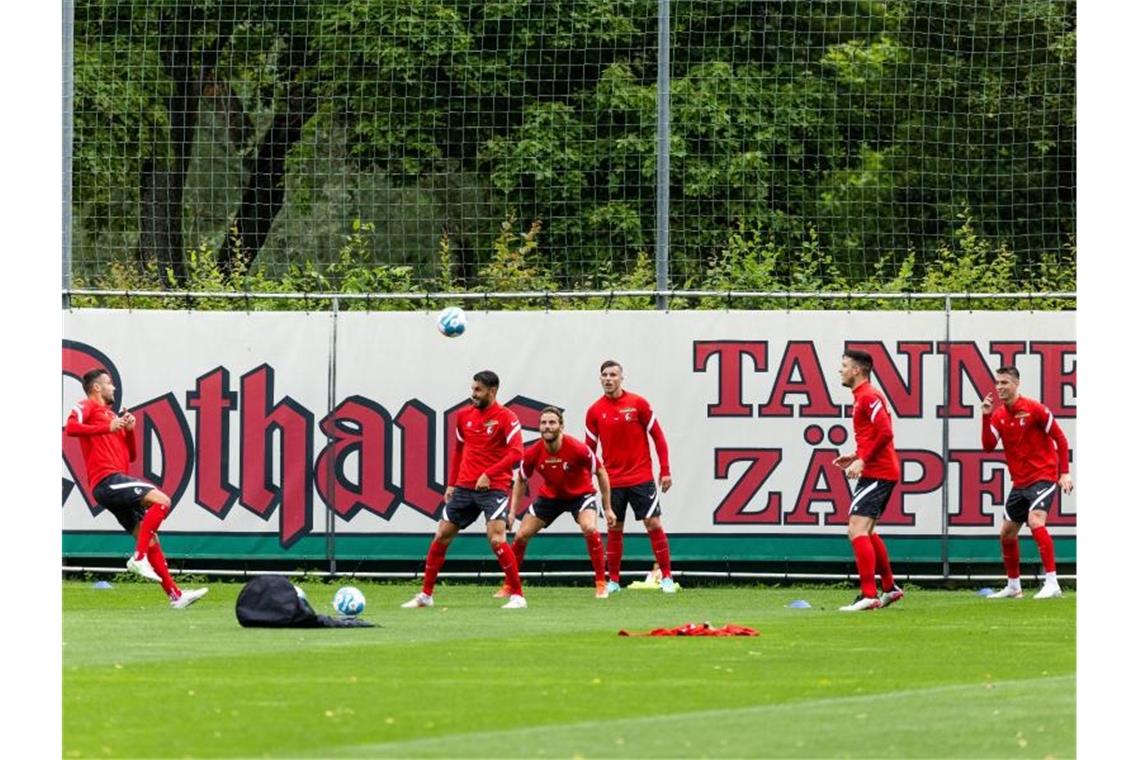 Freiburgs Spieler stehen auf dem Trainingsplatz und üben mit dem Ball. Foto: Philipp von Ditfurth/dpa