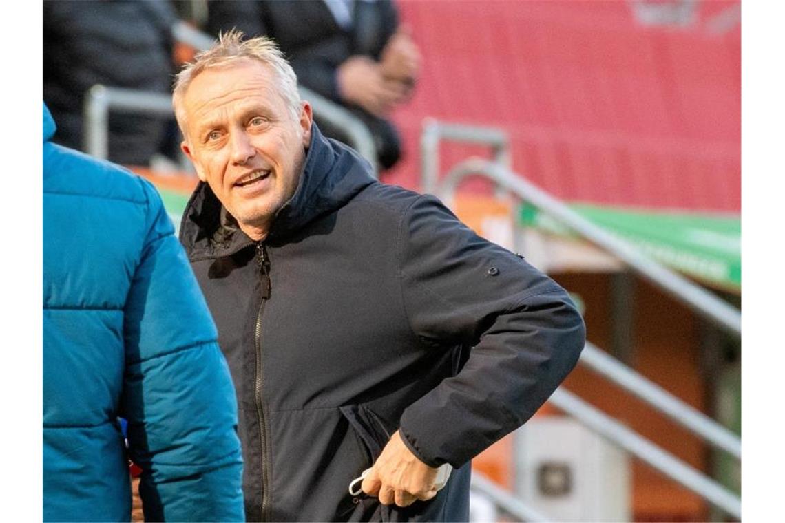 Freiburgs Trainer Christian Streich verstaut seine Atemmaske. Foto: Stefan Puchner/dpa