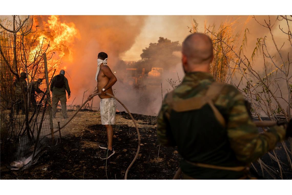 Freiwillige löschen einen Waldbrand in Ano Patima in der Region Nord-Athen