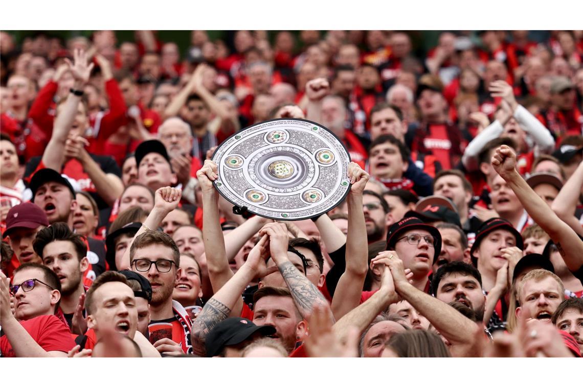 Fußball: Ein Leverkusener Fan hält während des Spiels eine Nachbildung der Meisterschale in den Händen. Bayer Leverkusen gewinnt die Deutsche Meisterschaft.