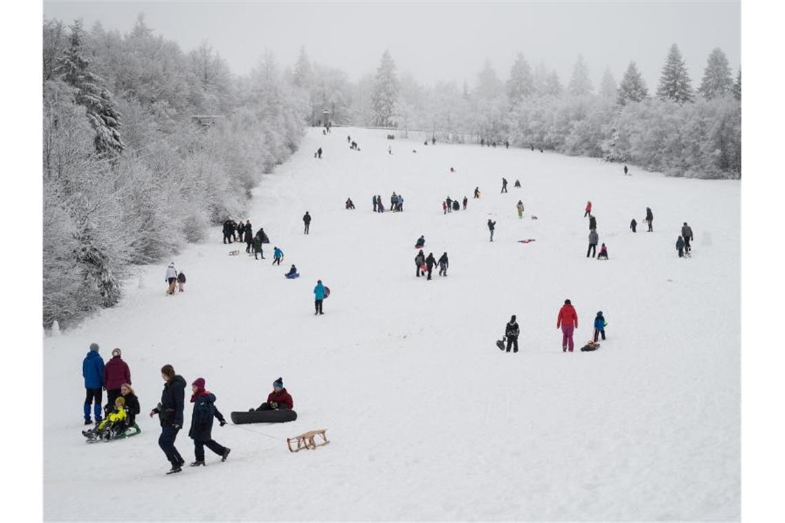 Weiter Andrang in Wintersportorten - Laschet mahnt Fußgänger und Schlittenfahrer sind auf einer Piste in Winterberg unterwegs. Foto: Bernd Thissen/dpa