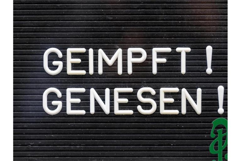 „Geimpft! Genesen!“ steht auf einem Schild an einer Bar. Foto: Robert Michael/dpa-Zentralbild/dpa/Symbolbild