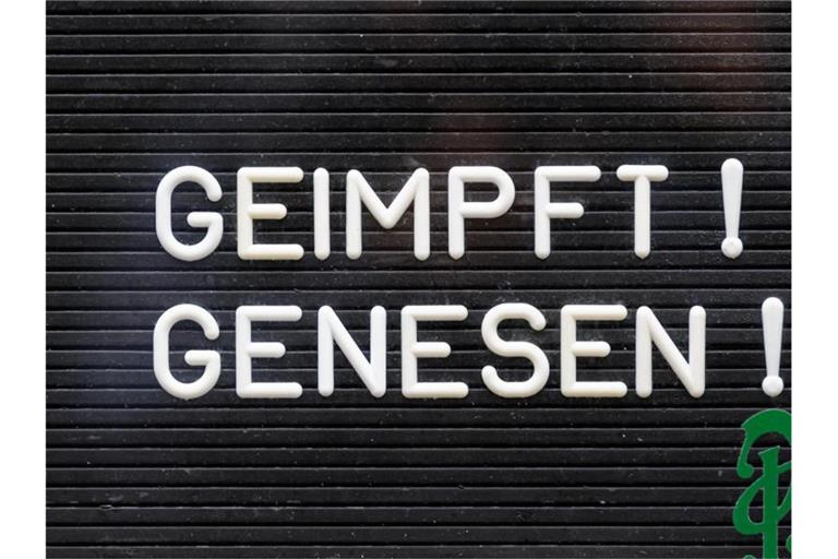 „Geimpft! Genesen!“ steht auf einem Schild an einer Bar. Foto: Robert Michael/dpa-Zentralbild/dpa/Symbolbild