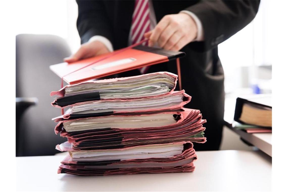 Gerichtsakten liegen auf einem Tisch. Foto: Christian Charisius/dpa/Symbolbild