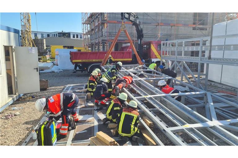 Gesichert durch einen Kran der Feuerwehr befreien Einsatzkräfte den Verletzten.