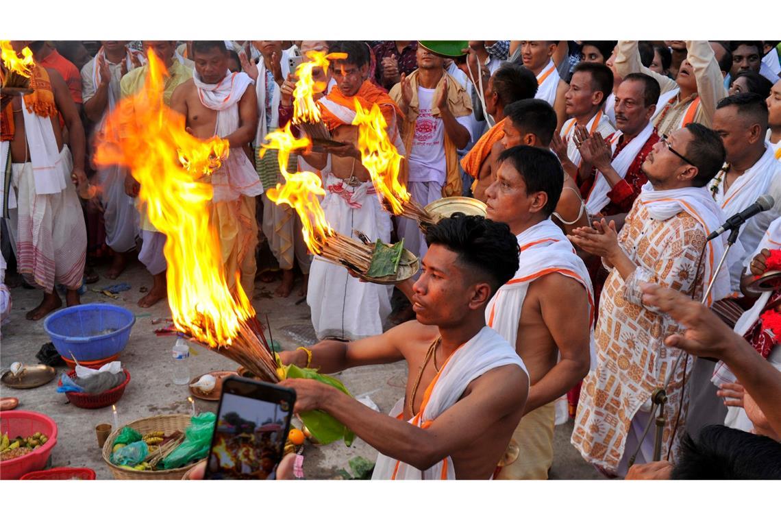 Gläubige nehmen mit brennenden Holzscheiten an den Ritualen beim Ratha-Yatra-Festival in Bangladesch teil.