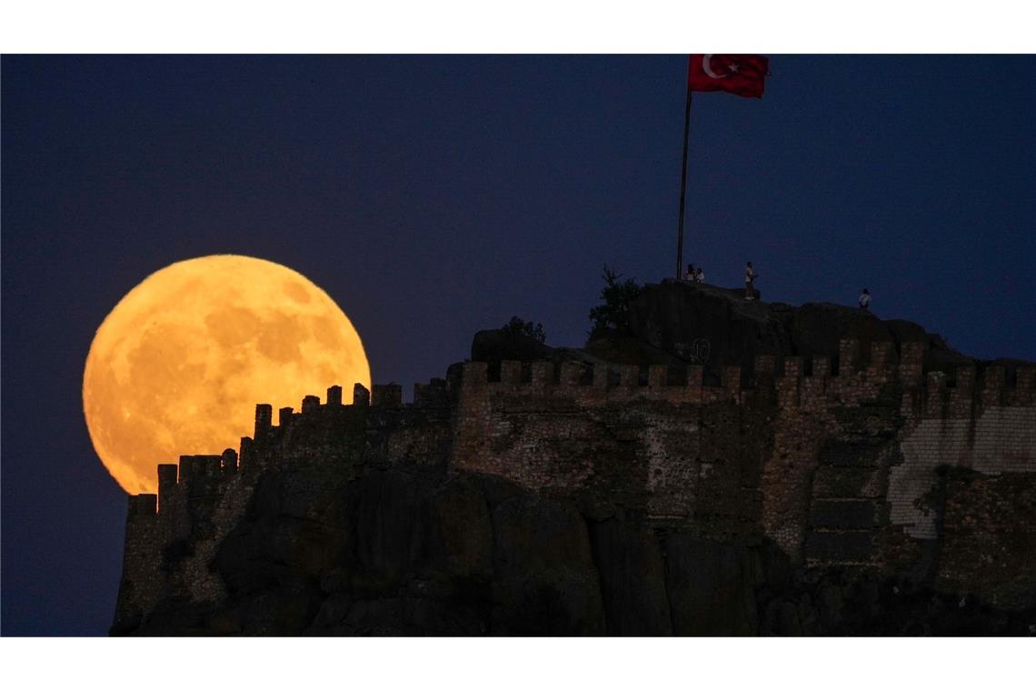 Groß und gelb: Der Vollmond geht hinter der alten Burg Karahisar in Afyonkarahisar in der Zentraltürkei auf.