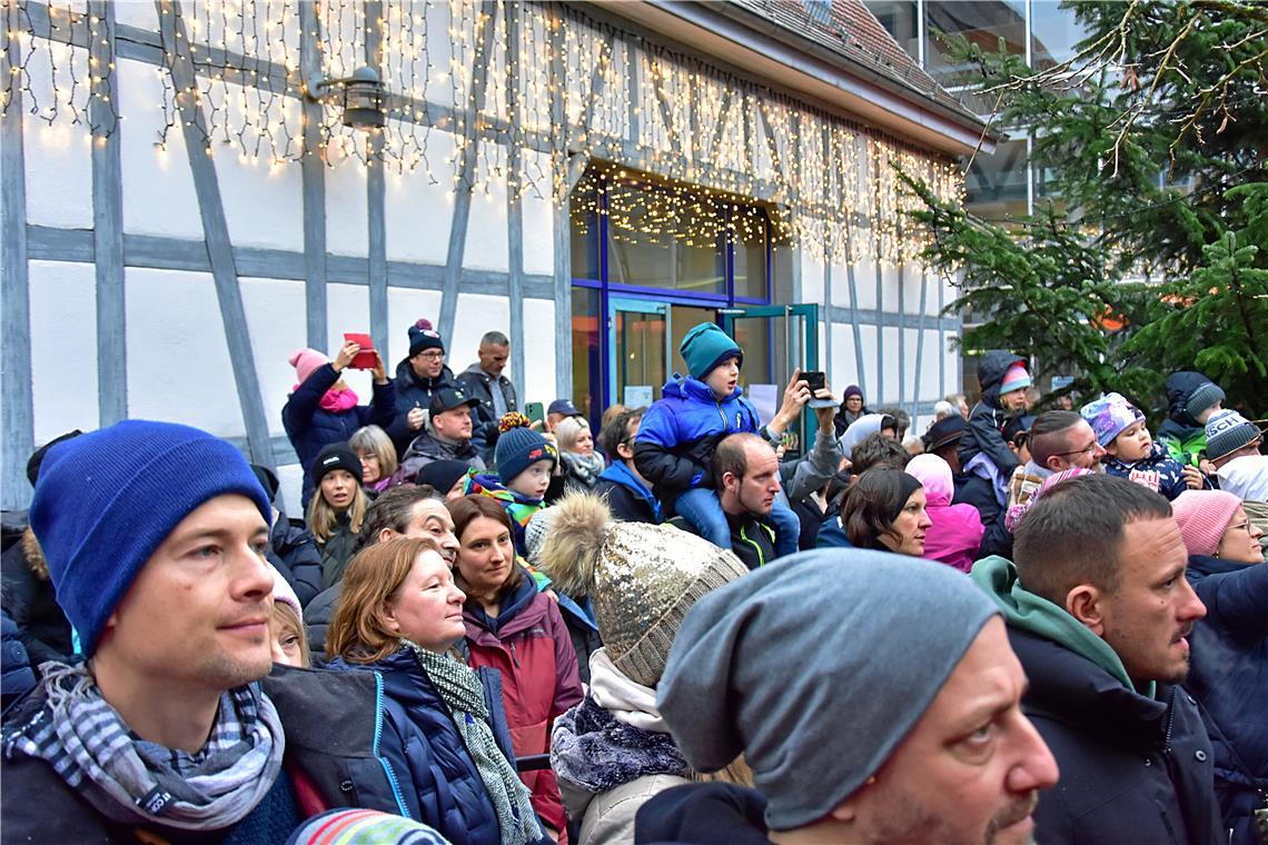 Großeltern, Eltern und Geschwister lauschen den Weihnachtsliedern der Schülerinn...